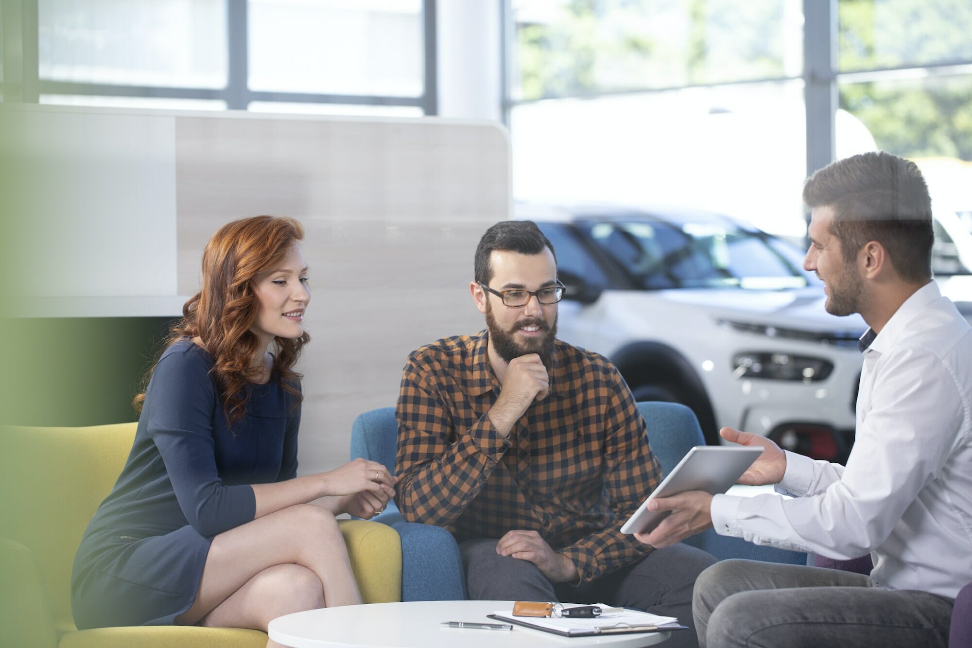 Car dealer showing an offer to his happy clients in a car showro
