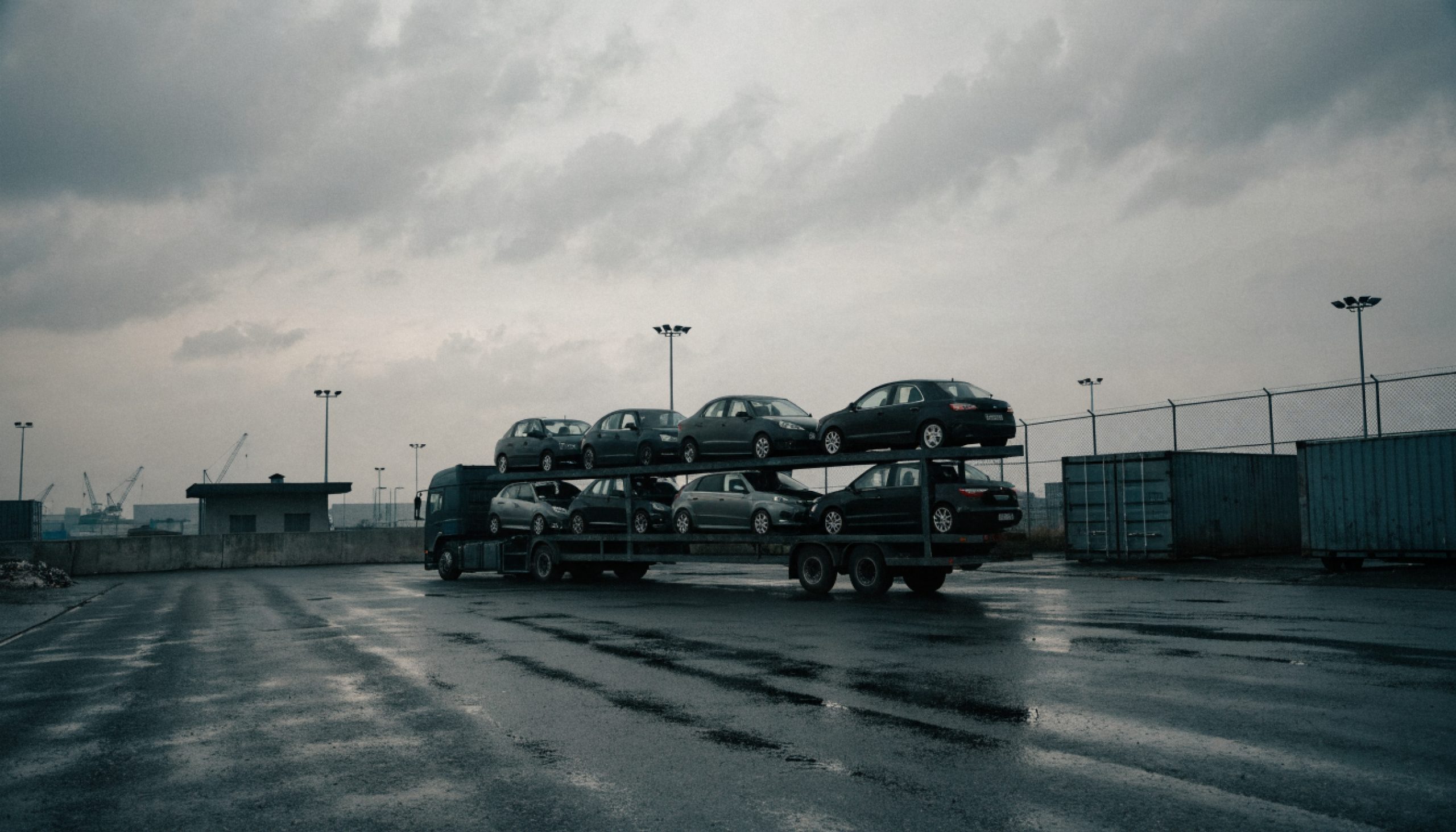 A car transporter with imported used vehicles at a customs terminal